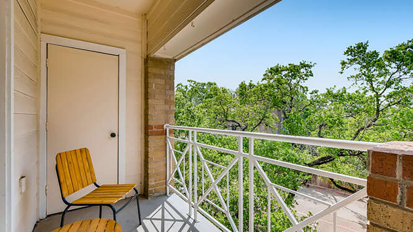 apartment balcony with seating and view of courtyard grounds