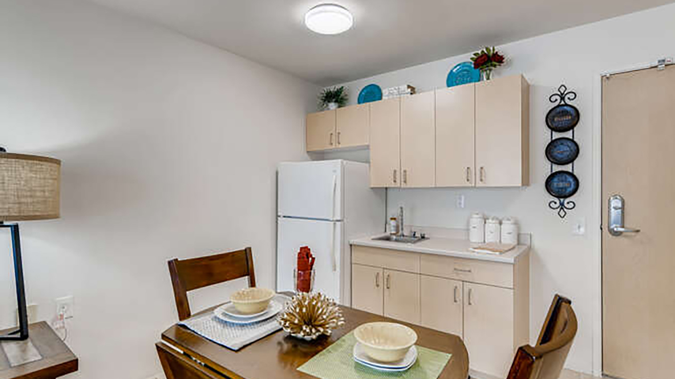 Senior apartment at Holiday Tremont with kitchenette, refrigerator and cabinetry.